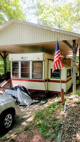 a view of house with backyard and furniture