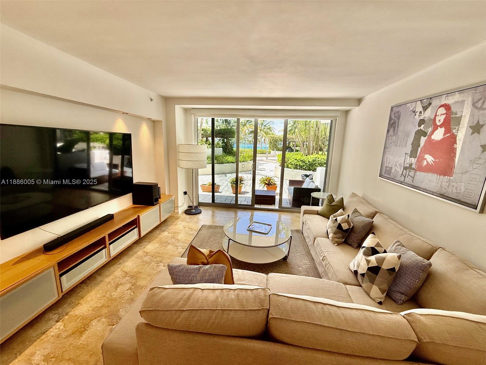 1500 Bay Road, Unit 122S Miami Beach, FL 33139 - Photo 1 of 44 a living room with furniture and a flat screen tv