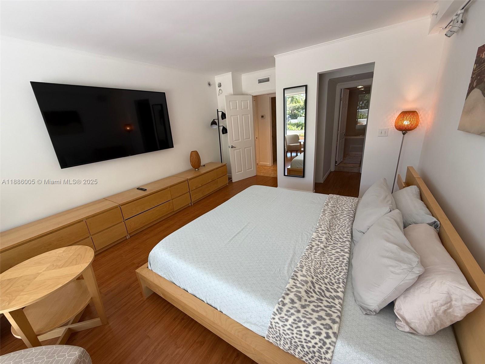 1500 Bay Road, Unit 122S Miami Beach, FL 33139 - Photo 15 of 44 a bedroom with a bed and a flat screen tv