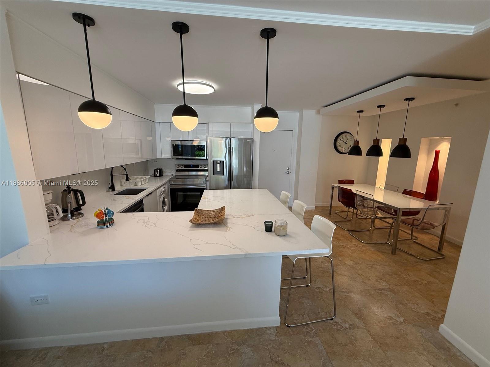 1500 Bay Road, Unit 122S Miami Beach, FL 33139 - Photo 6 of 44 a kitchen with a sink a counter and chairs