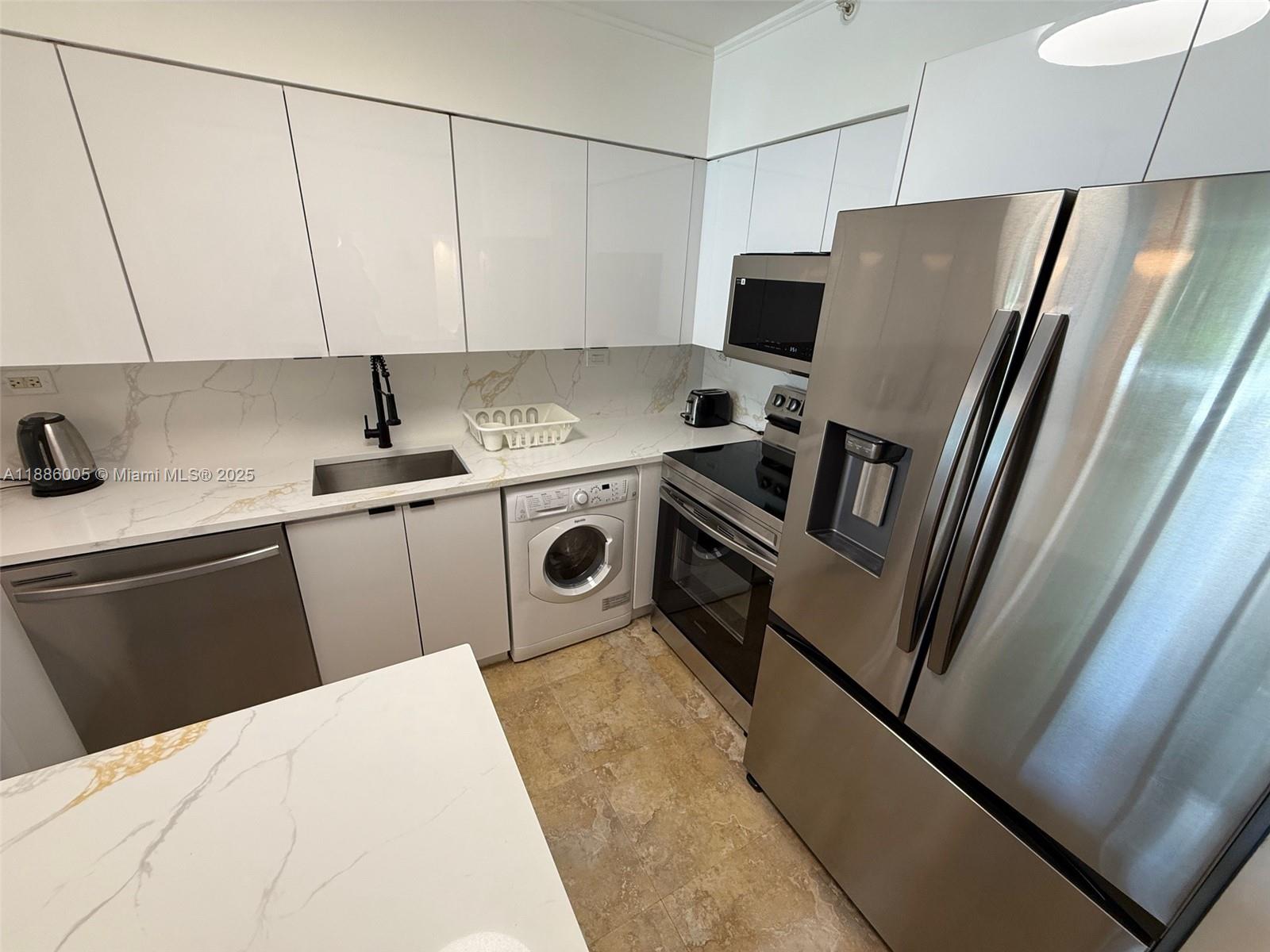 1500 Bay Road, Unit 122S Miami Beach, FL 33139 - Photo 8 of 44 a kitchen with stainless steel appliances a refrigerator stove a sink and a refrigerator
