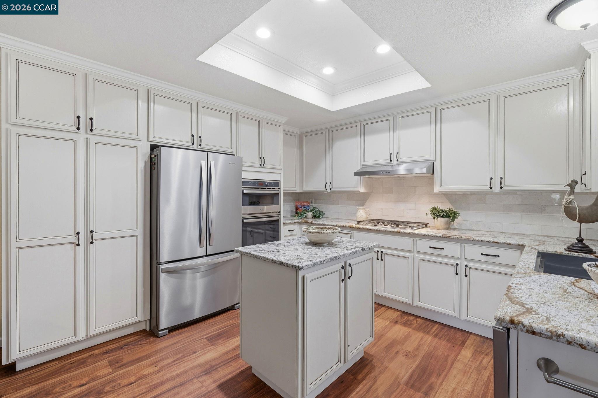1707 Geary Road Walnut Creek, CA 94597 - Photo 10 of 43 a kitchen with a refrigerator stove and sink with wooden floor