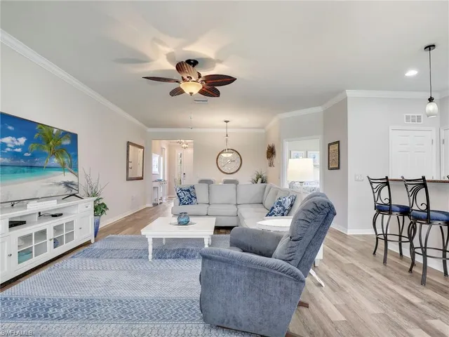 a kitchen with stainless steel appliances kitchen island granite countertop a stove top oven a sink a refrigerator with a dining table and chairs with wooden floor