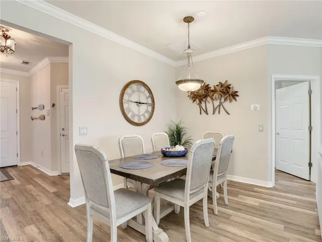 a view of a dining room with furniture a chandelier and wooden floor