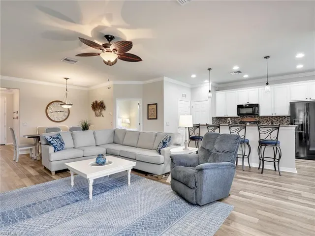 a living room with furniture kitchen view and a chandelier