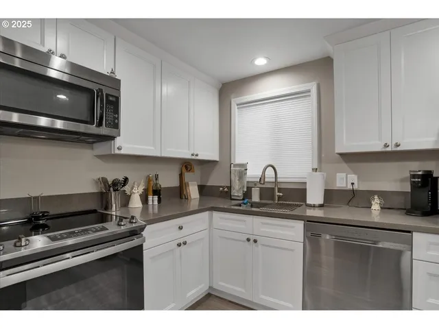a kitchen with stainless steel appliances granite countertop a sink a stove a microwave and cabinets