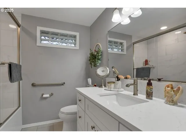 a bathroom with a granite countertop sink a toilet and a mirror