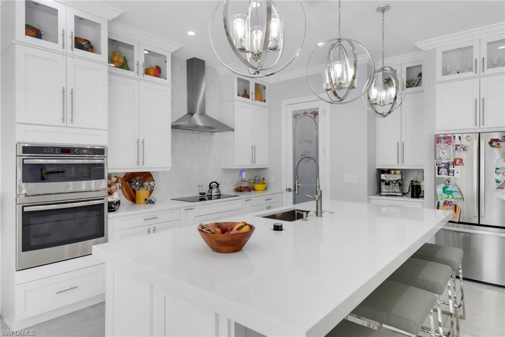 1086 21st Street Southwest Naples, FL 34117 - Photo 11 of 50 a kitchen with stainless steel appliances a stove a clock and cabinets