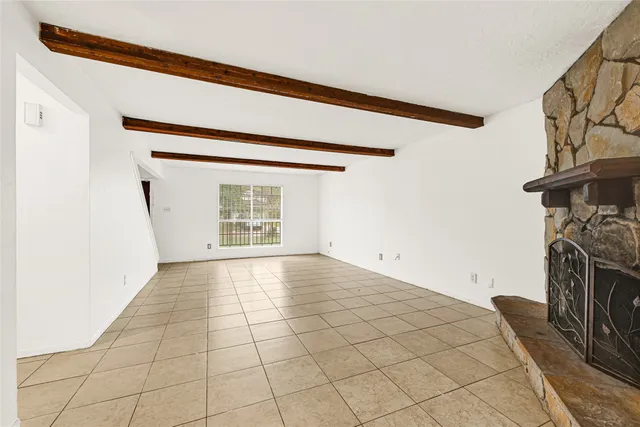 a view of an empty room with a fireplace and a window