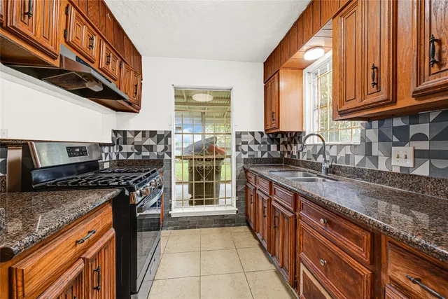 a kitchen with stainless steel appliances granite countertop a refrigerator and a sink