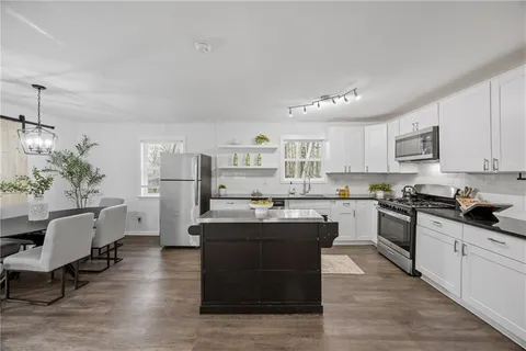 a kitchen with cabinets and wooden floor