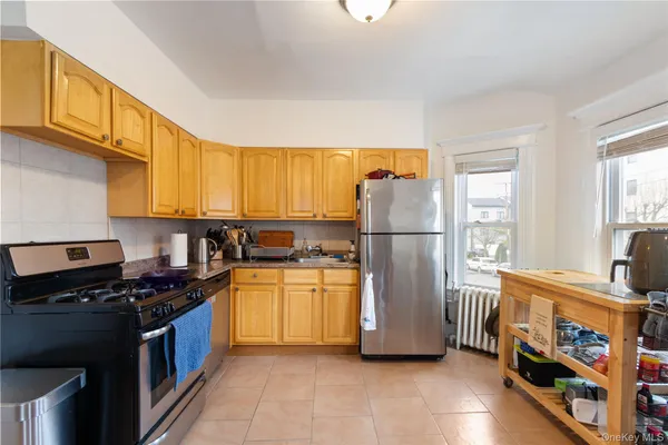 a kitchen with stainless steel appliances granite countertop a refrigerator a stove a sink and a microwave