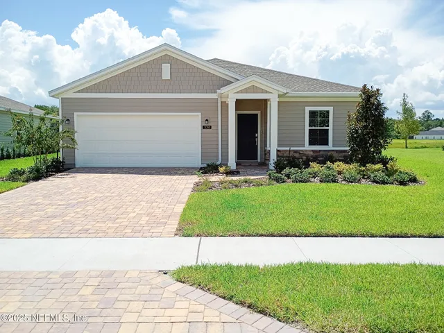 a front view of a house with a yard and trees