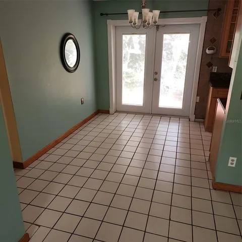 an empty room with windows and mirror