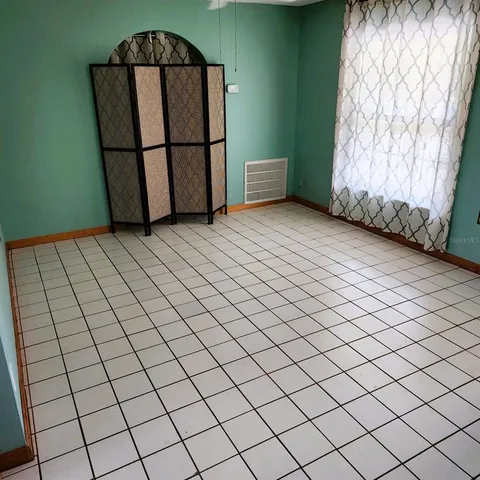 a view of a livingroom with wooden floor and a window