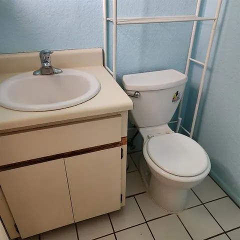 a white toilet sitting next to a bathroom sink