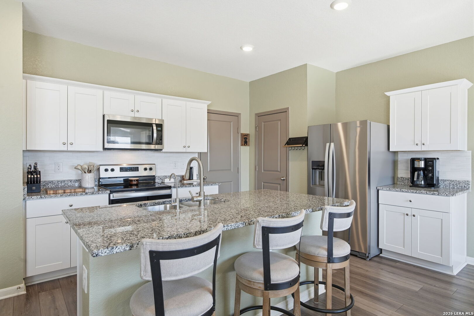5496 Rue Girard Converse, TX 78109 - Photo 12 of 40 a kitchen with stainless steel appliances granite countertop a table chairs microwave and refrigerator