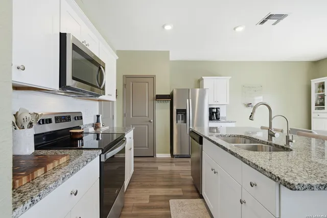 a kitchen with stainless steel appliances granite countertop a sink and a stove