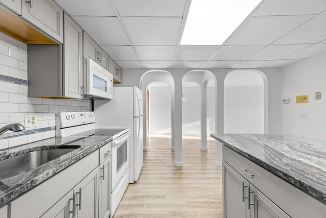 a kitchen with stainless steel appliances granite countertop a sink a stove and cabinets