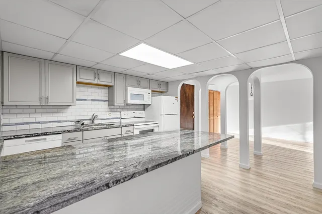 a view of a kitchen with stainless steel appliances granite countertop a sink and cabinets