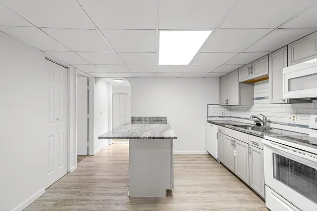 a kitchen with stainless steel appliances granite countertop a stove a sink and a refrigerator