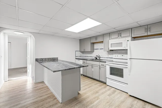 a kitchen with stainless steel appliances granite countertop a white stove top oven and white cabinets