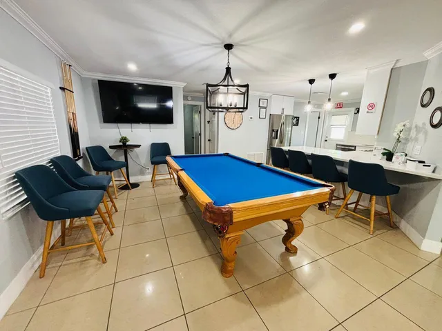 a living room with furniture a flat screen tv and kitchen view