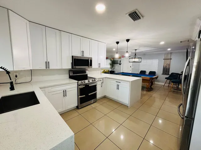 a kitchen with a sink a stove top oven and cabinets