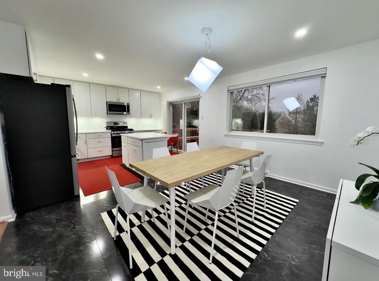 4203 Main Street Alexandria, VA 22309 - Photo 3 of 6 a kitchen with stainless steel appliances a dining table chairs and a refrigerator