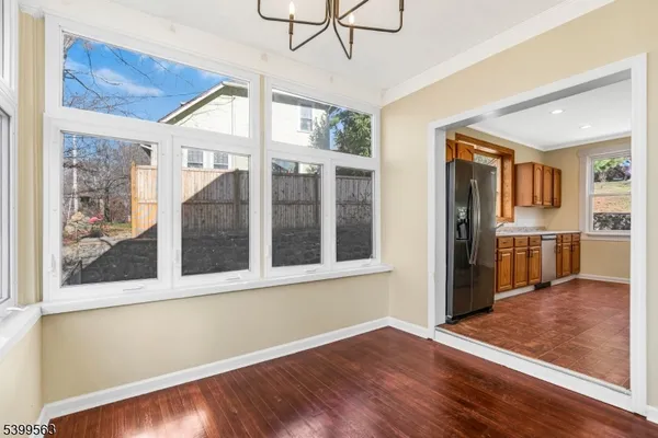 a view of a large room with wooden floor and a kitchen