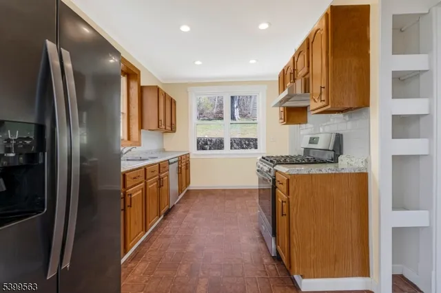 a kitchen with stainless steel appliances granite countertop a refrigerator and a stove top oven