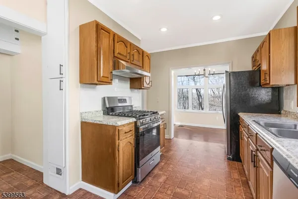 a kitchen with stainless steel appliances granite countertop a stove a sink and a refrigerator