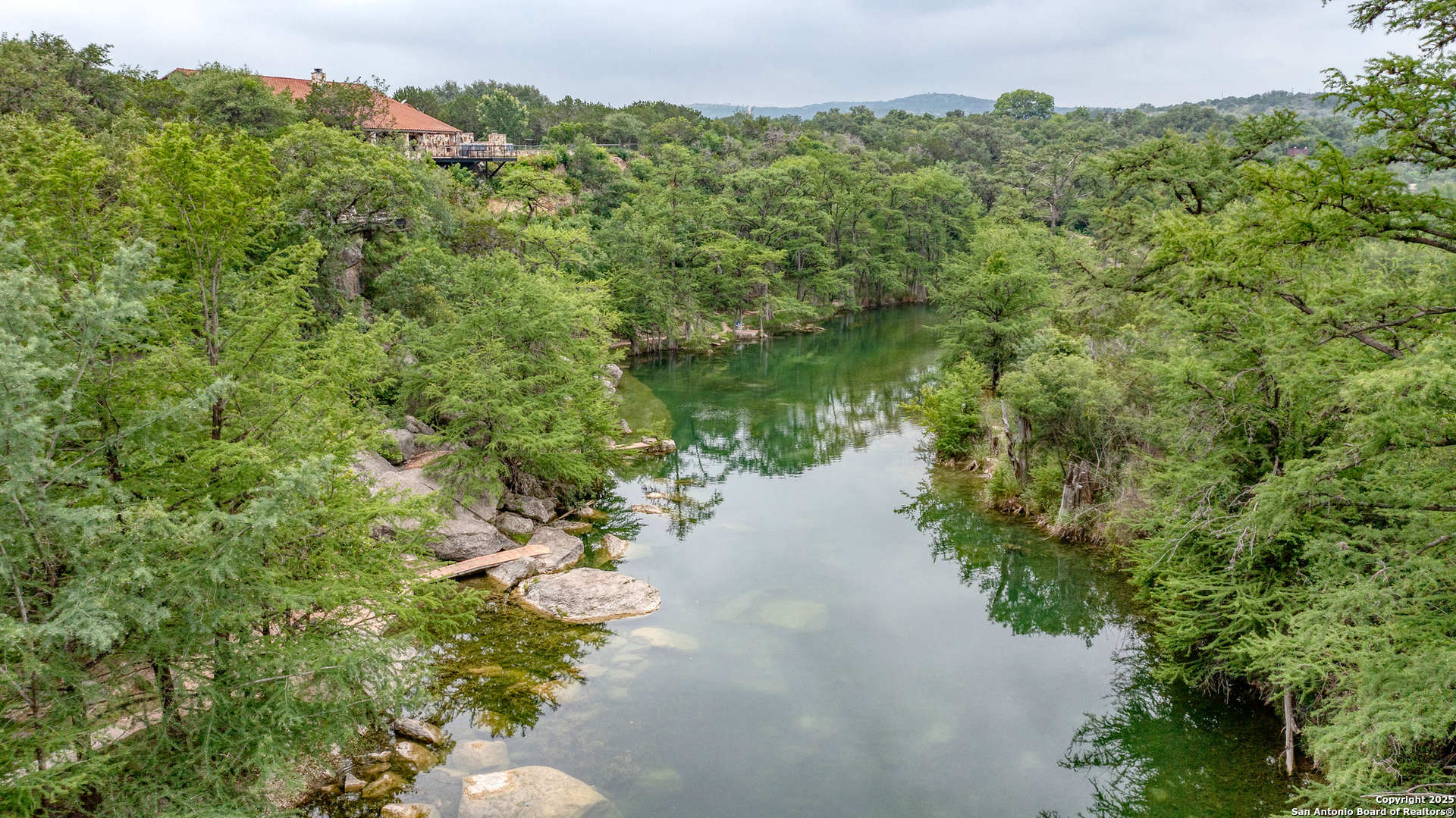 22 Camino Del Rancho Concan, TX 78838 - Photo 12 of 16 a view of a lake with a lush green forest