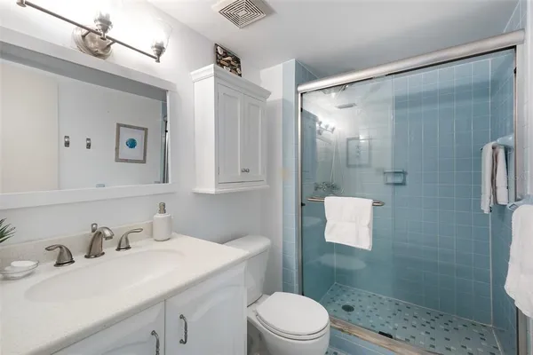 a bathroom with a sink toilet a mirror and shower
