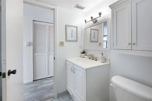 a bathroom with a toilet a sink a mirror and a shower