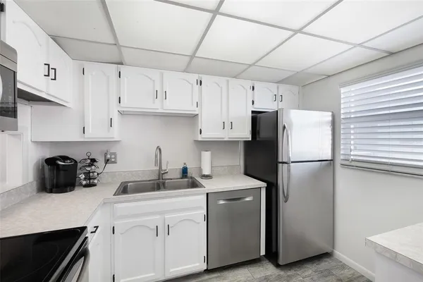 a kitchen with refrigerator a stove a sink and cabinets