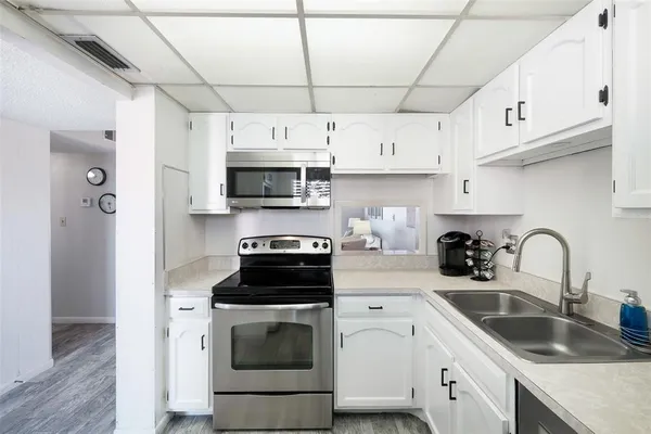 a kitchen with stainless steel appliances granite countertop a sink a stove and cabinets