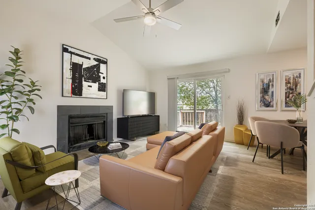 a living room with furniture large window and fireplace