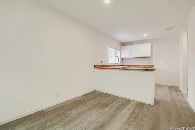 a room with wooden floor and cabinets