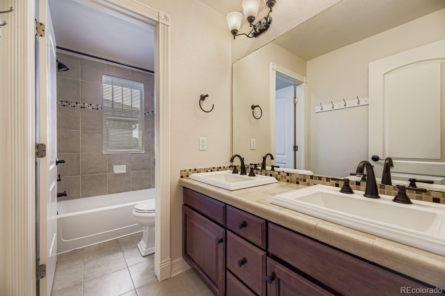 4927 South Addison Way Aurora, CO 80016 - Photo 21 of 24 a bathroom with a sink a toilet and shower