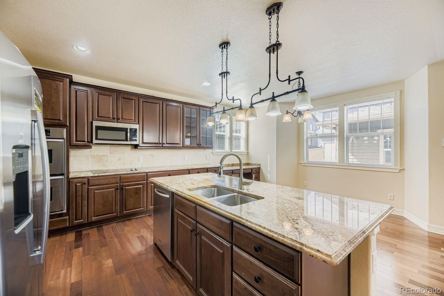 4927 South Addison Way Aurora, CO 80016 - Photo 6 of 24 a kitchen with stainless steel appliances granite countertop a sink stove and refrigerator