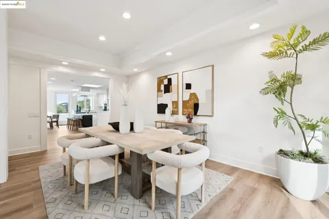 a large white kitchen with lots of counter top space and stainless steel appliances