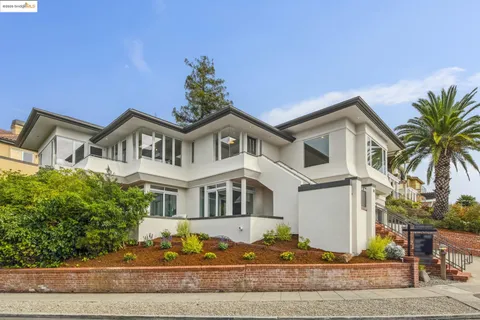 a front view of a house with a yard and potted plants