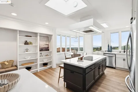 a kitchen with a stove sink and dining table with wooden floor