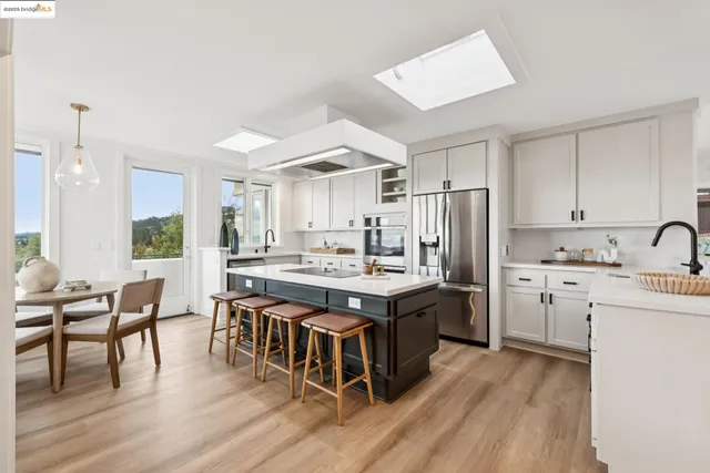 a kitchen with appliances cabinets and chairs