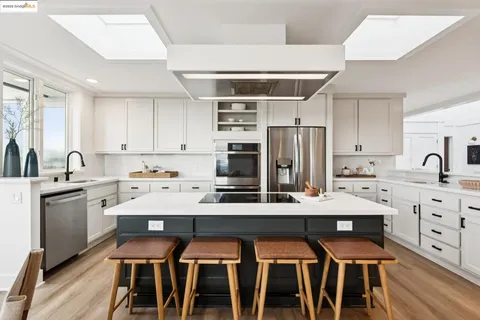 a open kitchen with stainless steel appliances kitchen island granite countertop a sink and cabinets