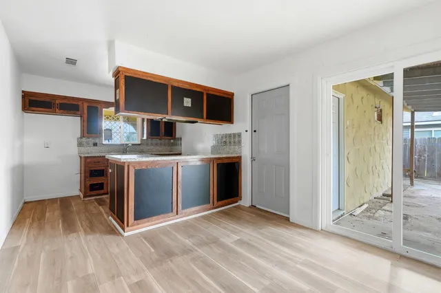 a view of kitchen with stainless steel appliances granite countertop a stove and a sink