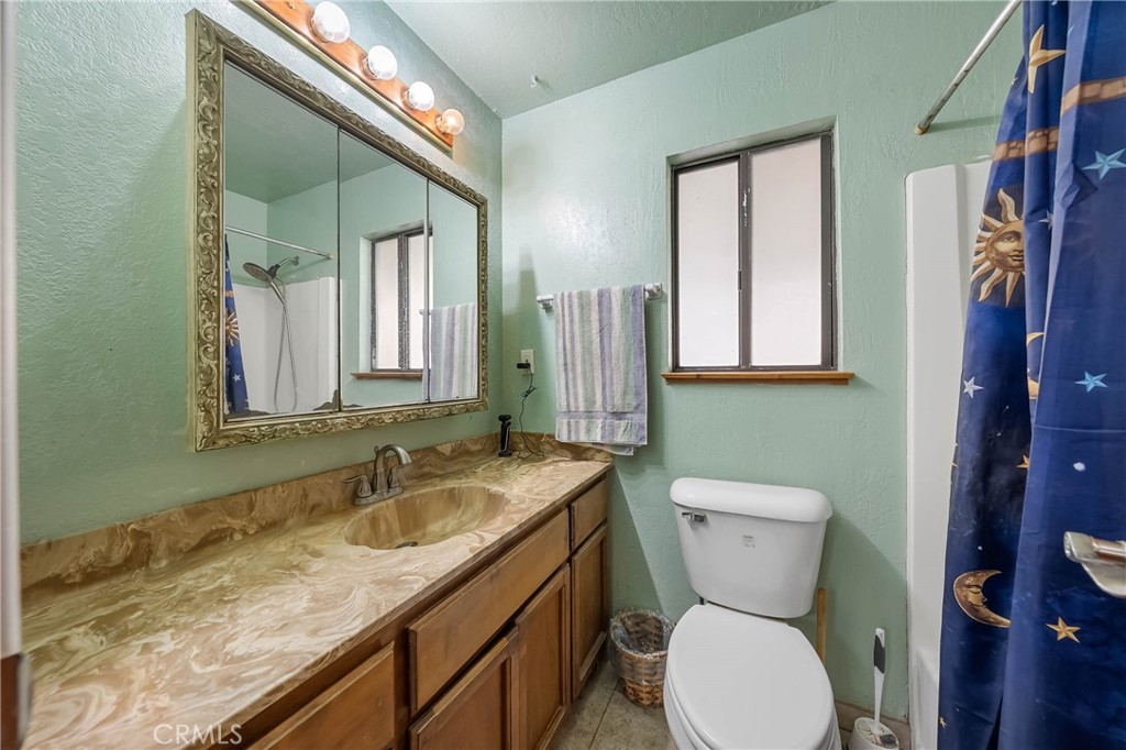 2976 Rancho Vista Drive Lucerne, CA 95458 - Photo 37 of 51 a bathroom with a granite countertop toilet sink and mirror