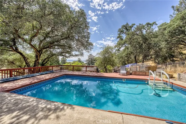 a view of a swimming pool with lawn chairs under an umbrella