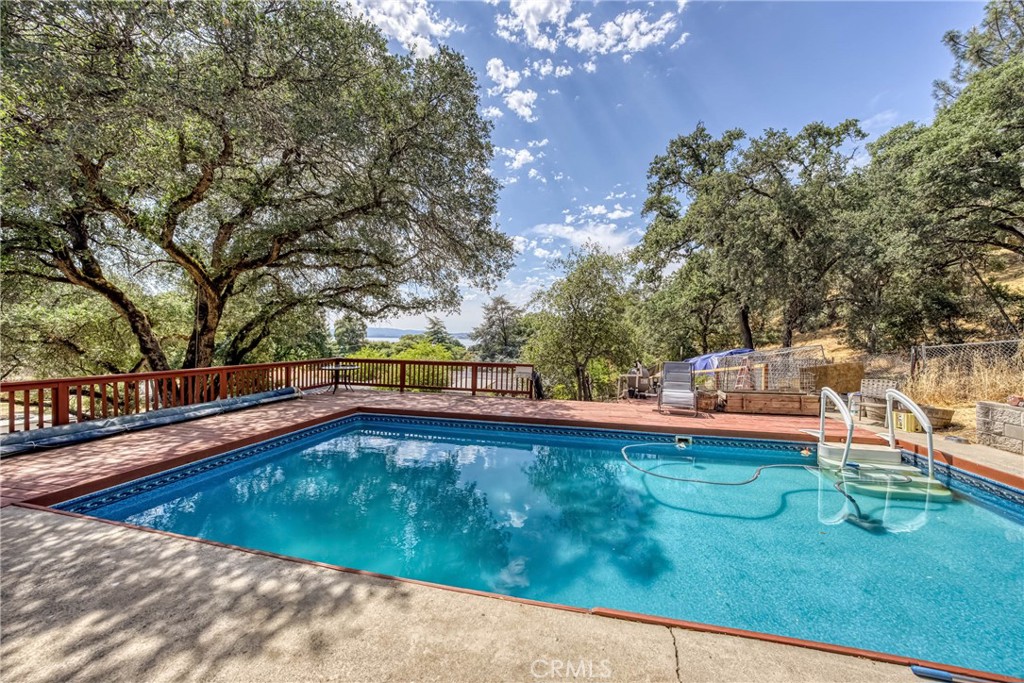 2976 Rancho Vista Drive Lucerne, CA 95458 - Photo 10 of 51 a view of a swimming pool with lawn chairs under an umbrella